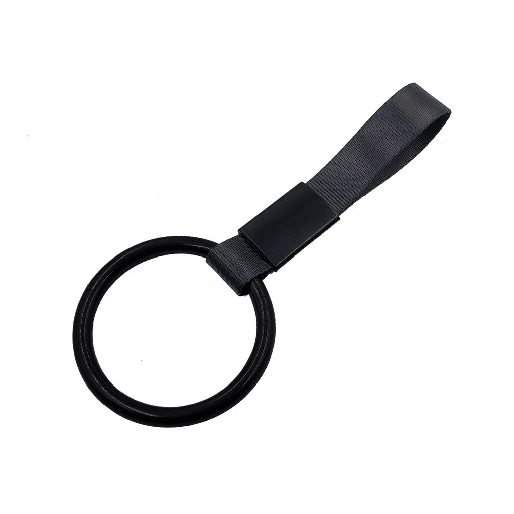 A black ring tsurikawa with black handle strap flat laid on a white background