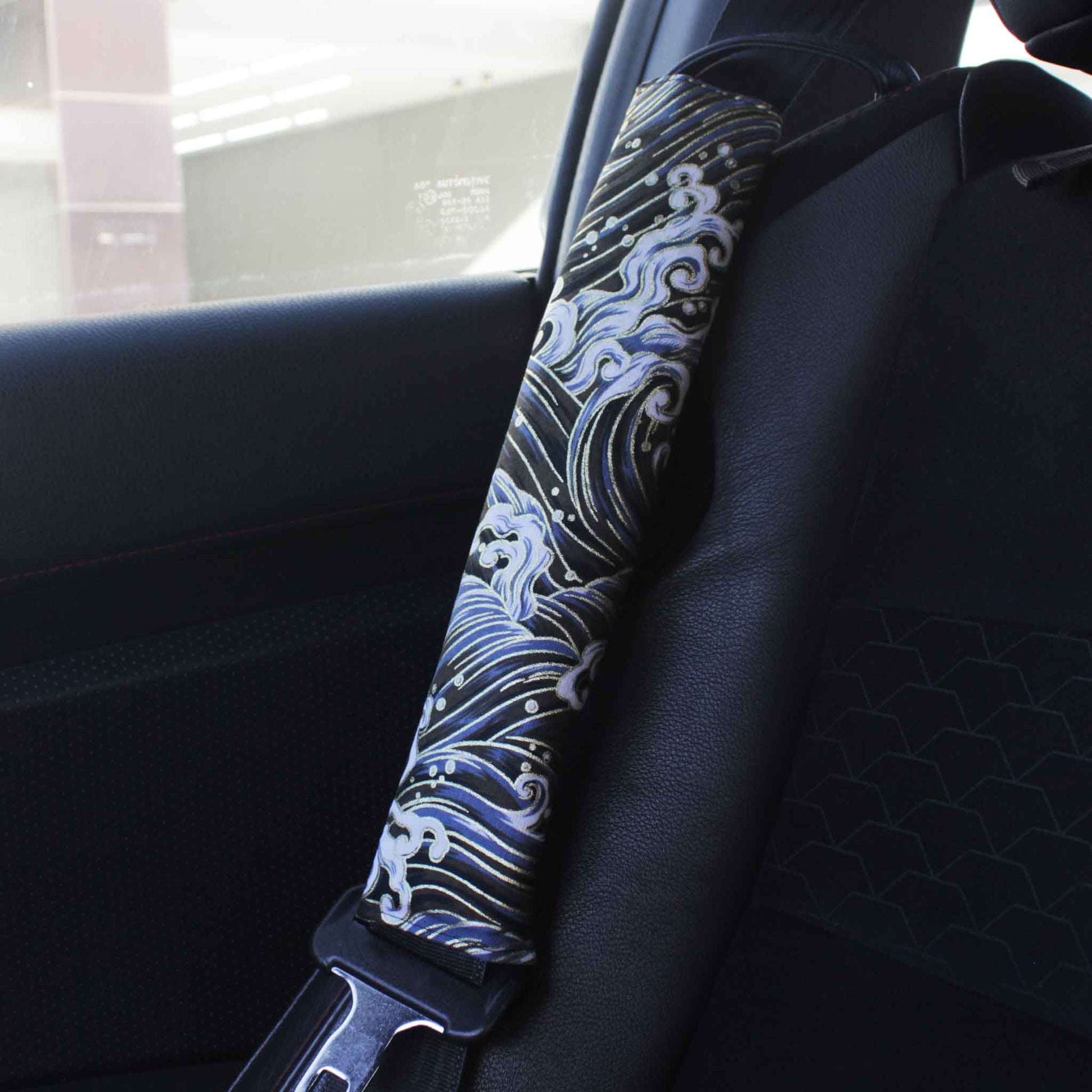 A seat belt cover with black great waves pattern installed on a Toyota 86's seat belt