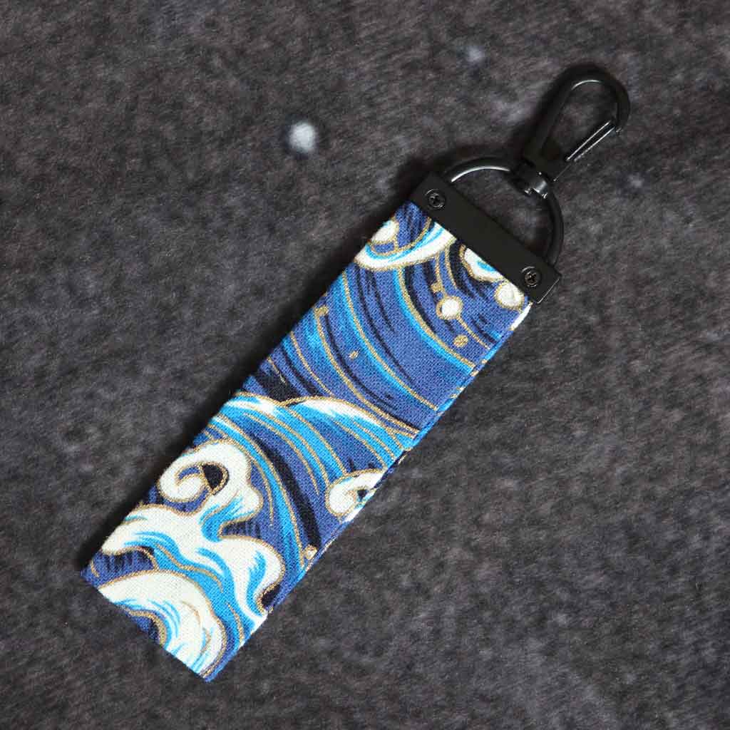 A blue wave keychain on a grey background