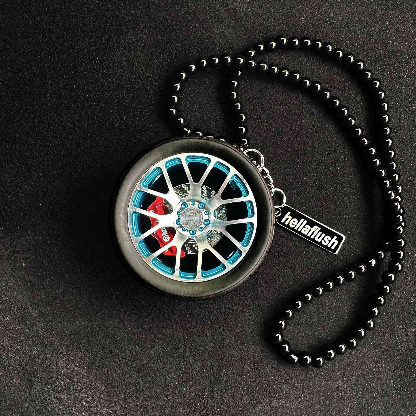 A blue BBS wheel air-freshener placed on a black background