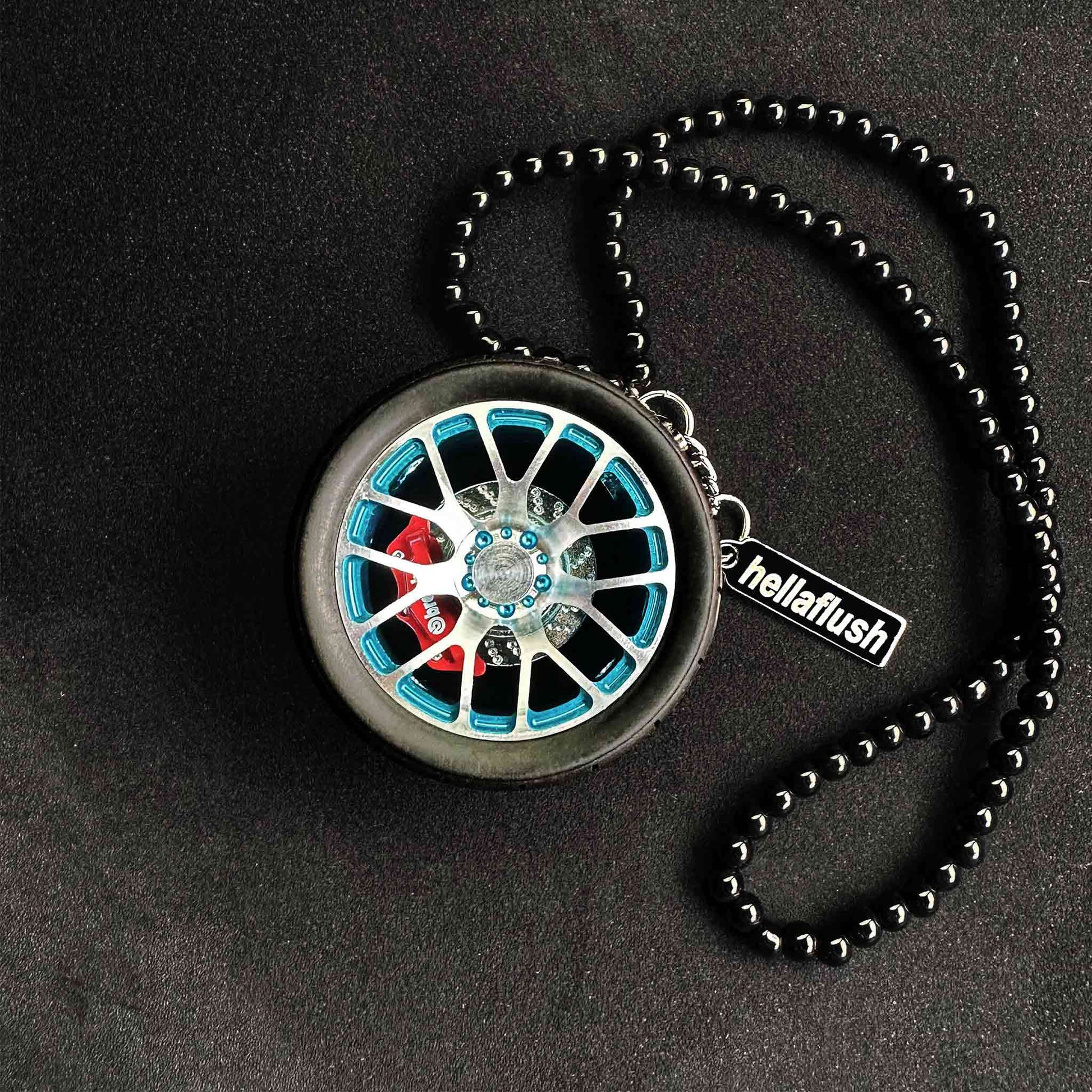A blue BBS wheel air-freshener placed on a black background