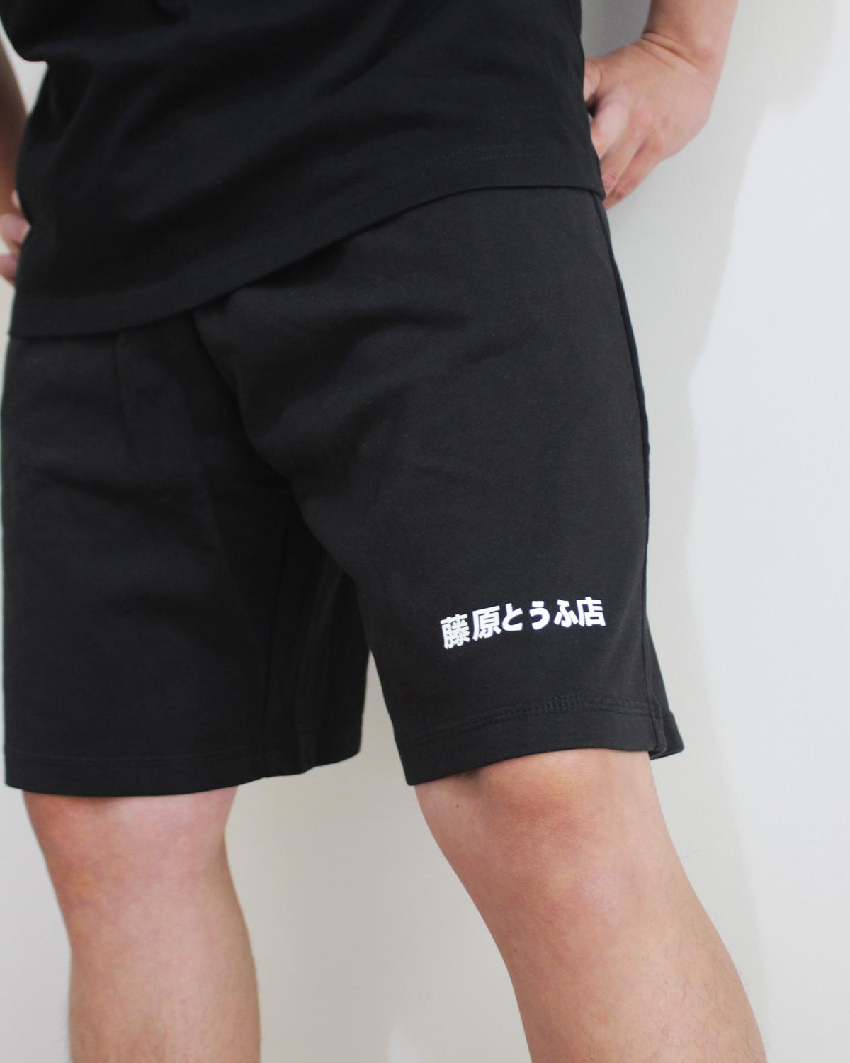 Close-up of the 'Initial-D' in Japanese printing on a black short pants