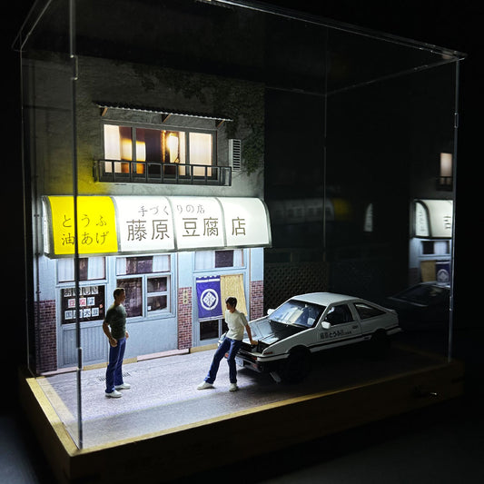 A double-storey Fujiwara tofu shop diorama in a acrylic case with mini figures and an AE86 model car inside