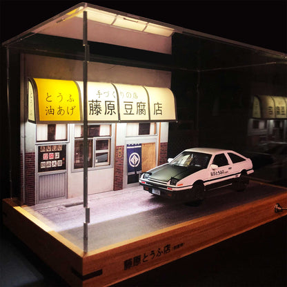 A Fujiwara tofu shop diorama with a clear case and an AE86 car model in it
