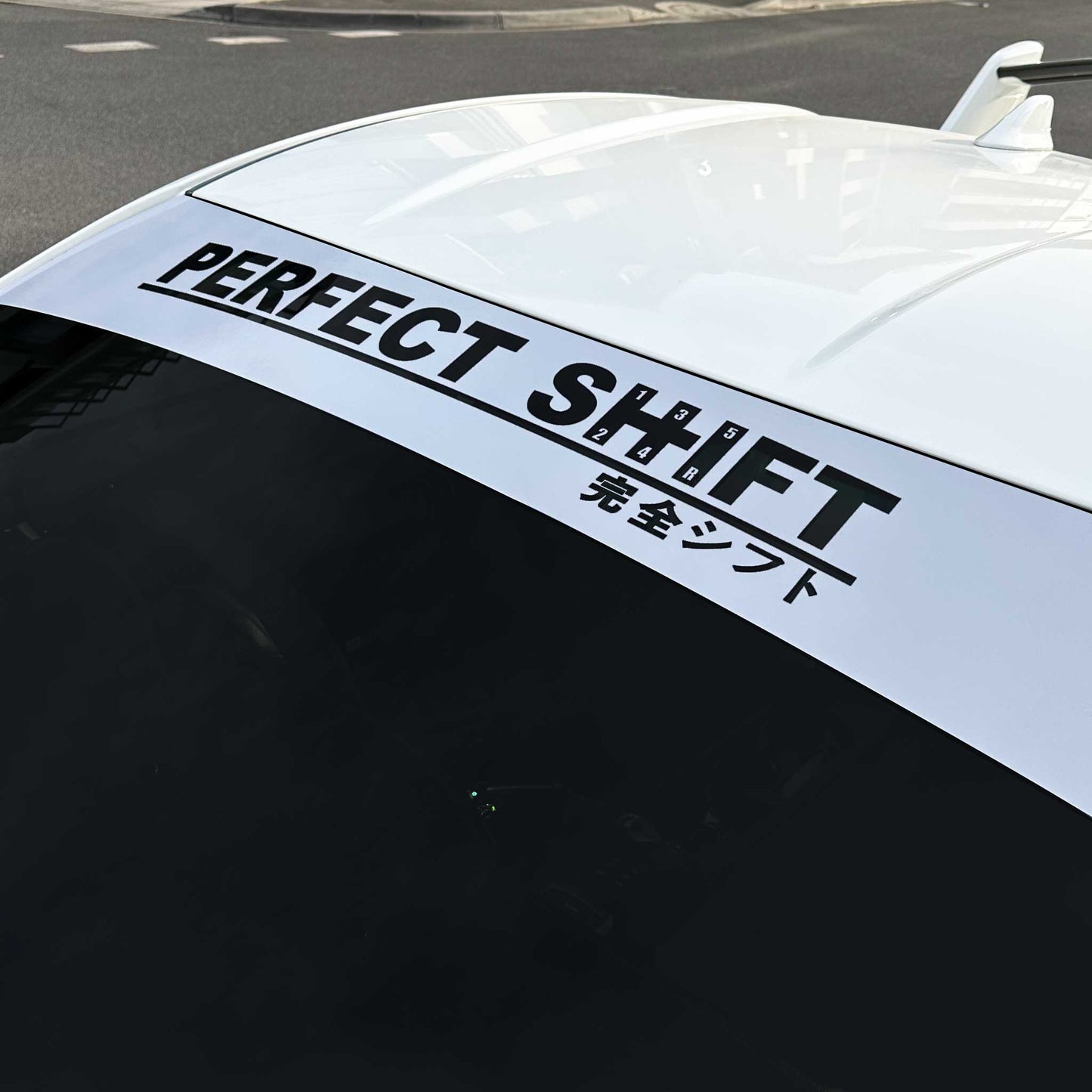 A branded Perfect Shift windshield banner with grey background applied on a Toyota 86 that is parked on street