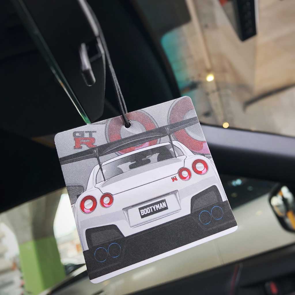 A GTR R35 Booty Man air freshener hung in a car