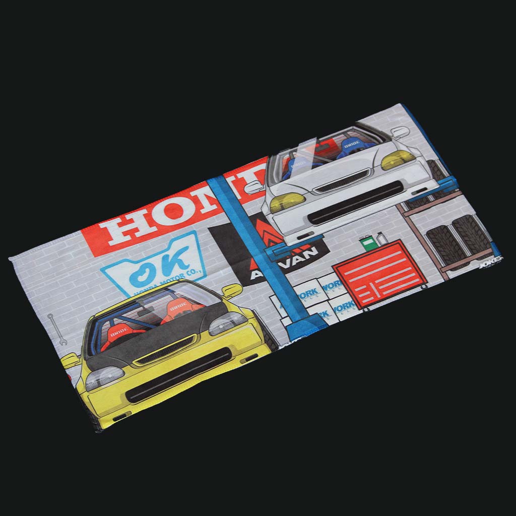 A car towel featuring two Honda cars at a work shop on a black background