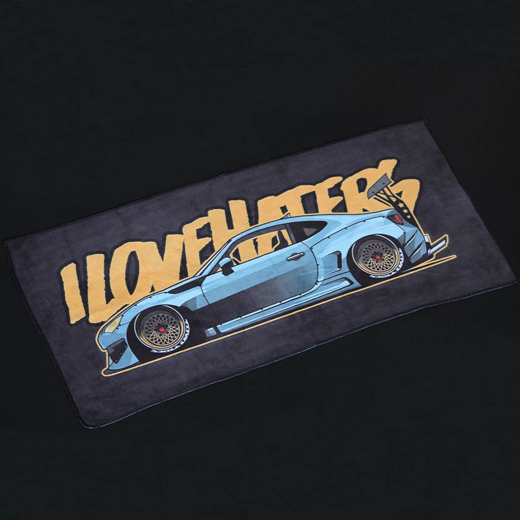 A car towel featuring a wide body BRZ and the yellow writing 'I love haters' on a black background