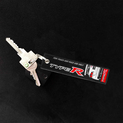 A type-r jet tag holding two keys on a black background