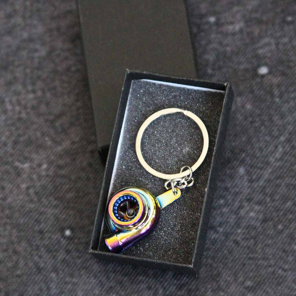 A rainbow turbo keychain in a gift box on a dark grey background