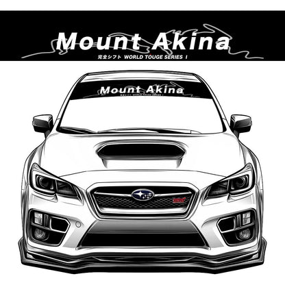 A black JDM car banner sticker with white character 'Mount Akina' on a Subaru WRX STI front window