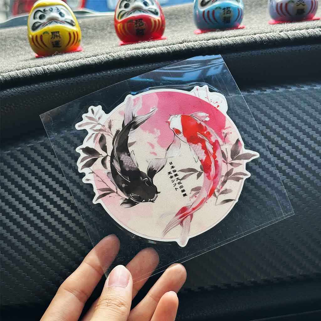 A hand holding a Japanese koi fish style JDM sticker