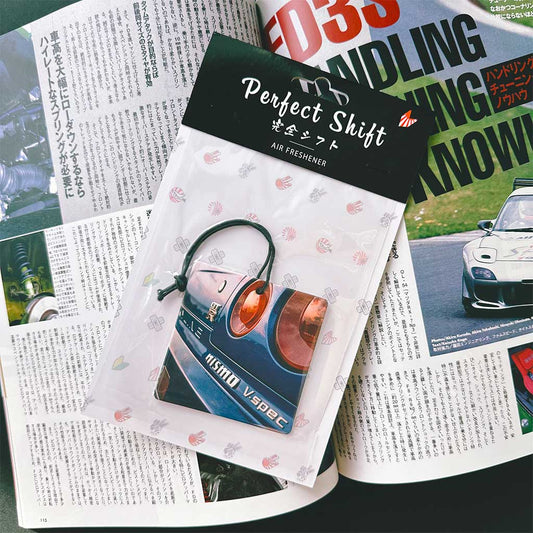 A JDM car air freshener themed Nissan Skyline GTR34 flat laid on a Japanese magazine