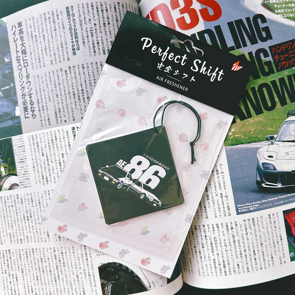 A JDM car air freshener themed Initial-D AE86 flat laid on a Japanese magazine