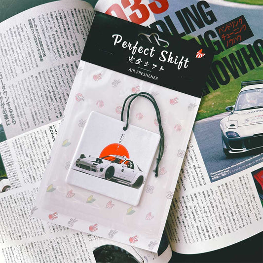 A JDM car air freshener themed NSX flat laid on a Japanese magazine