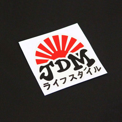 A JDM rising sun sticker on a black background