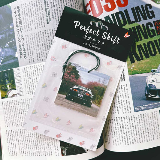 A JDM car air freshener themed Toyota supra flat laid on a Japanese magazine