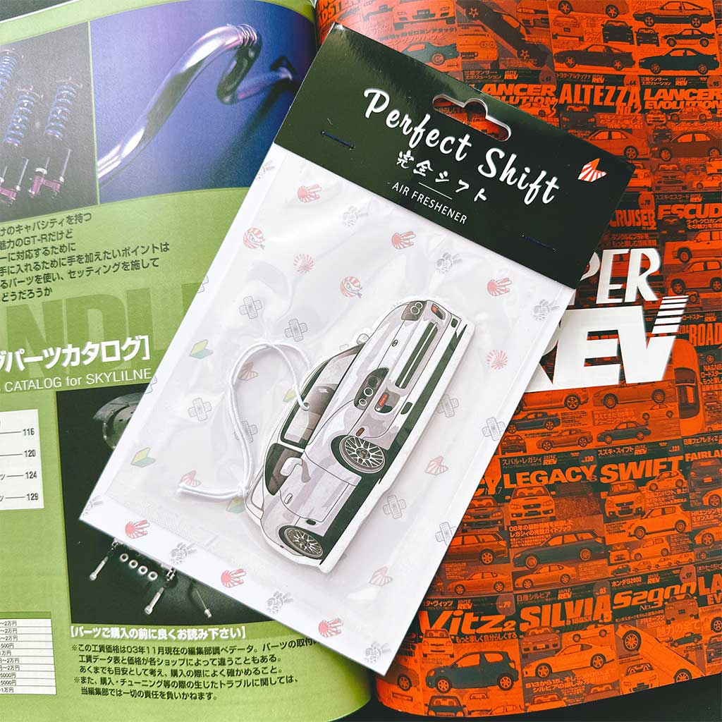 A JDM car air freshener themed supra flat laid on a Japanese magazine