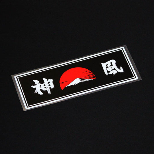 A Kamikaze slap sticker flat laid on a black background