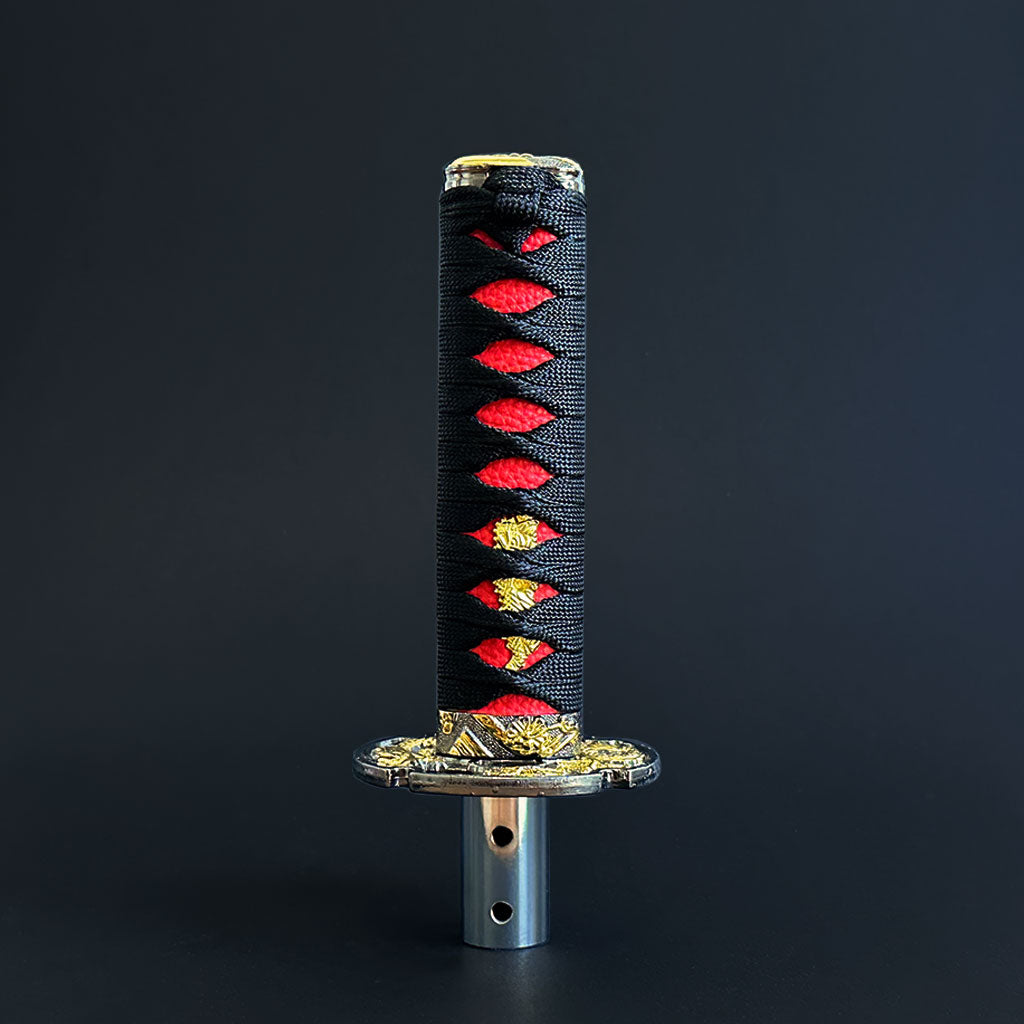 A black and red Katana shift knob standing in front of a black wall