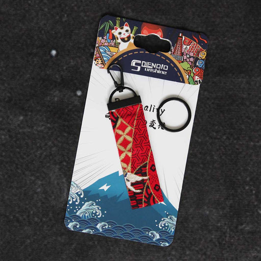 A red koi fish wafu keychain on a Japanese style packaging, on a grey background