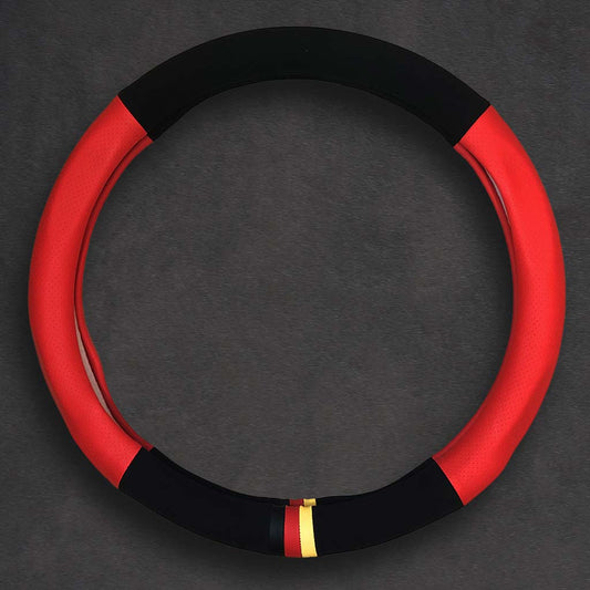 A black and red suede and leather steering wheel cover in O shape with three-coloured mark flat laid on a grey background