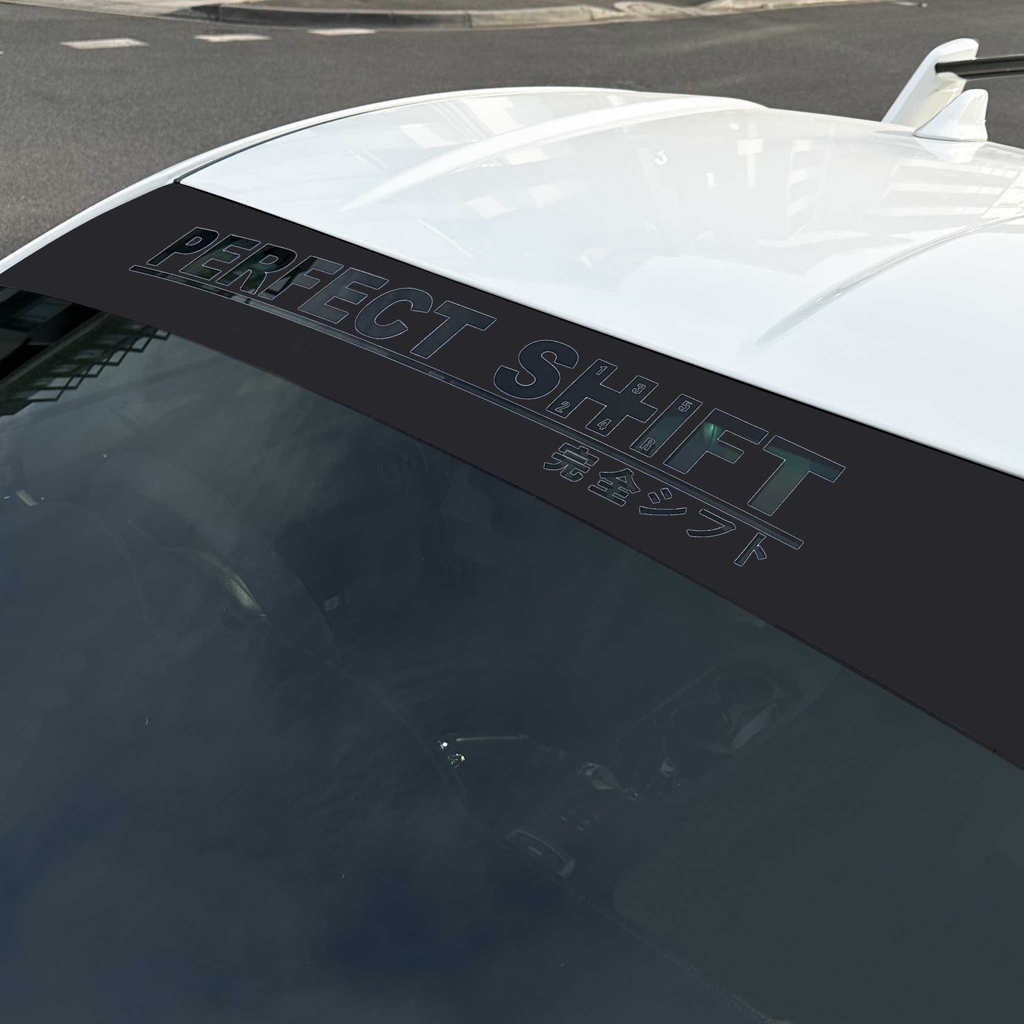 A branded Perfect Shift windshield banner with black background applied on a Toyota 86 that is parked on street