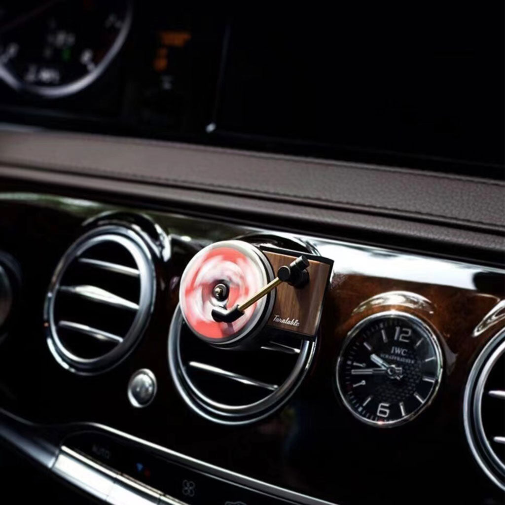 A mini record player air freshener clipped on a car's air-con vents is spinning fast