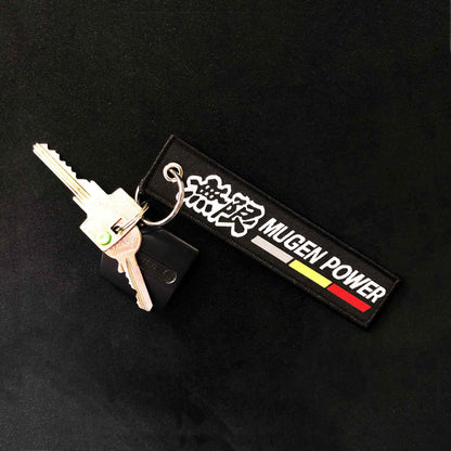 A black Mugen Power jet tag holding fob and keys on a black background