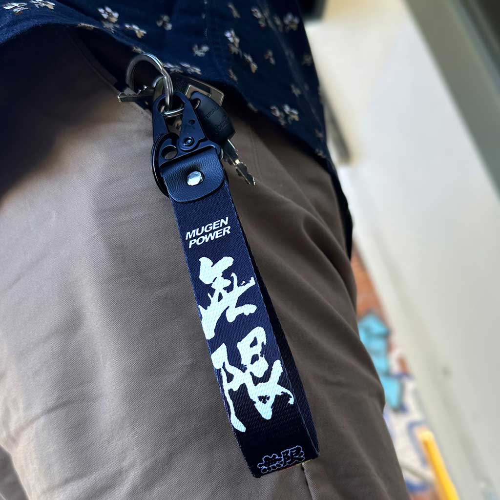 A black Mugen Power lanyard in a man's pocket