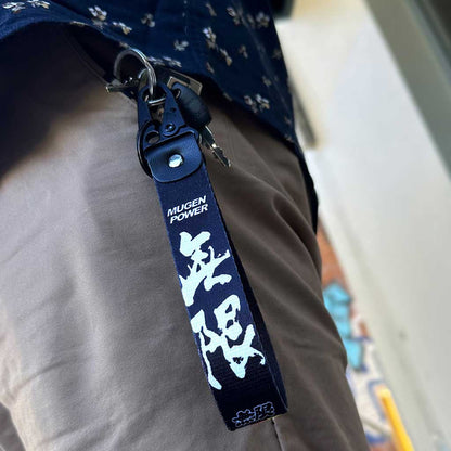 A black Mugen Power lanyard in a man's pocket