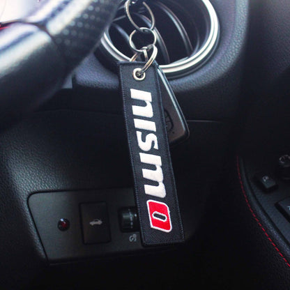 A nismo jet tag hung on a steering wheel control stick