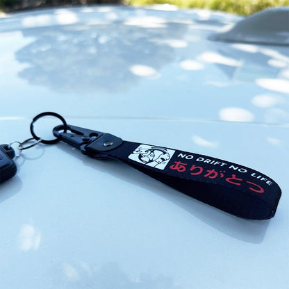 A No Drift No Life lanyard placed on top of a white Toyota 86