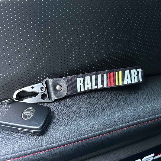 A ralli-art lanyard holding a Toyota car key in an 86.