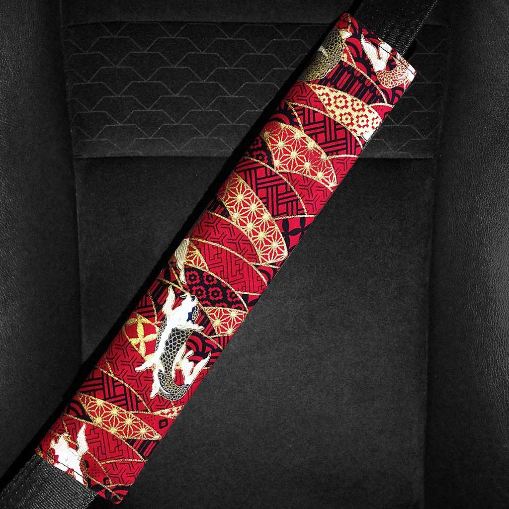 A red koi fish seat belt pad is installed in a car