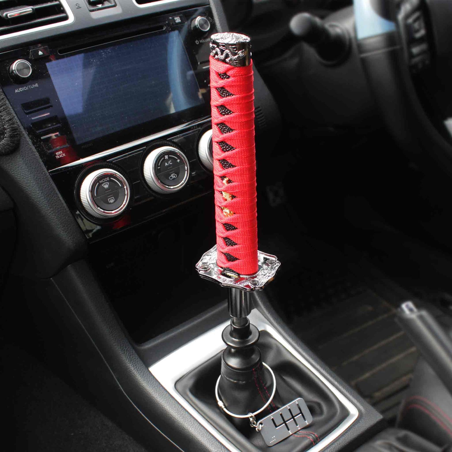A red katana shift knob is installed on a manual WRX, and a six-speed dog-tag is hanging around the shift boot