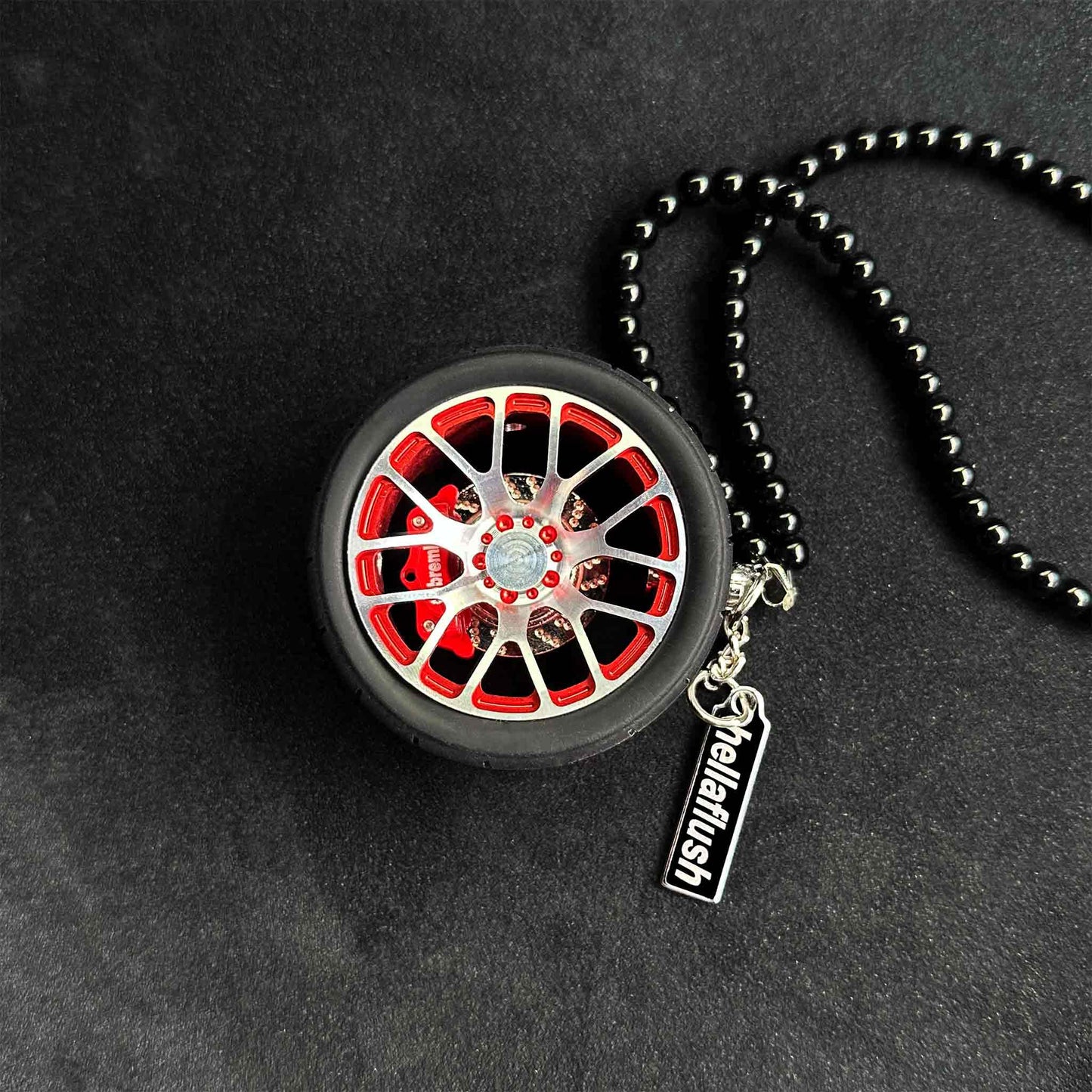 A red BBS wheel air-freshener placed on a black background