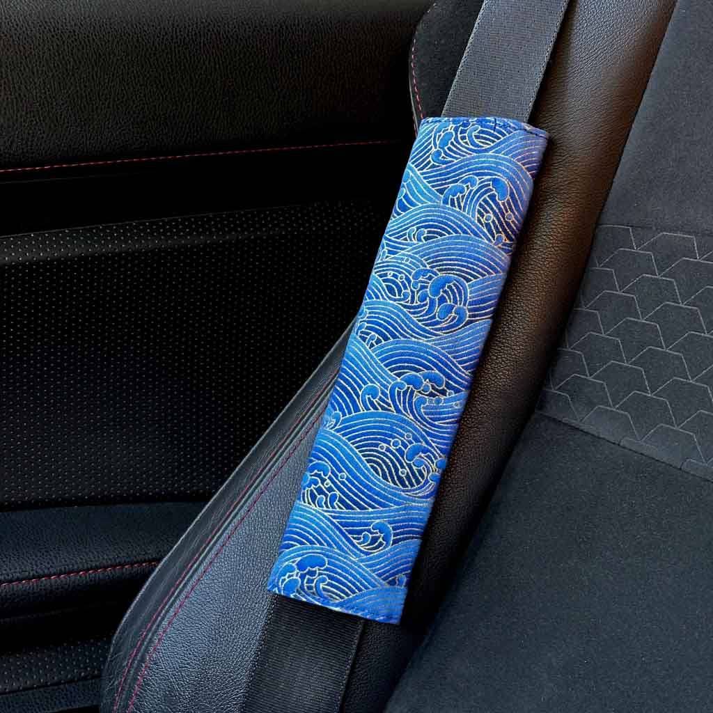 A piece of JDM seat belt cover featuring blue Japanese waves installed in a Toyota 86