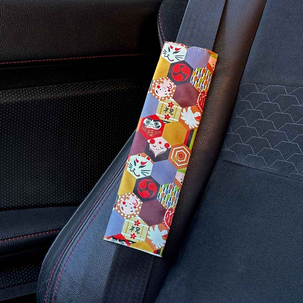 A piece of JDM seat belt cover featuring Japanese elements such as kitsune and daruma installed in a Toyota 86