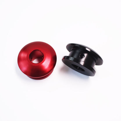 A non-threaded red boot retainer is standing upright with its top section pointing towards the screen, and a black one is flat laid next to it on a white background