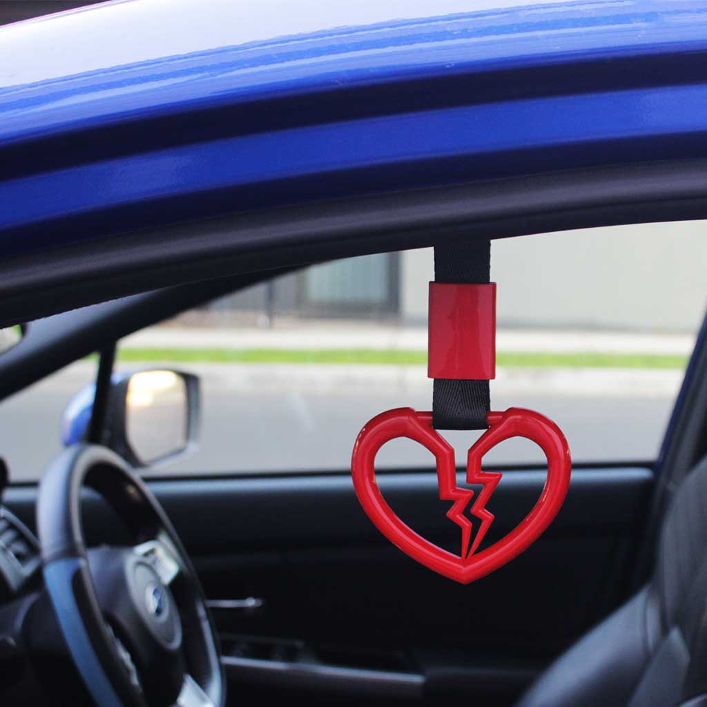A red broken heart Tsurikawas hung in a car