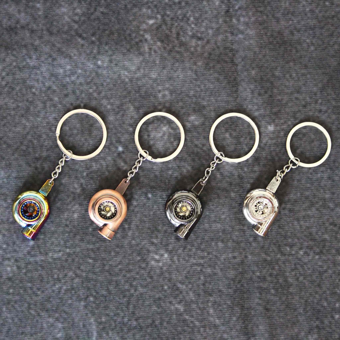 Four turbo keychains with different colours placed neatly on a grey background