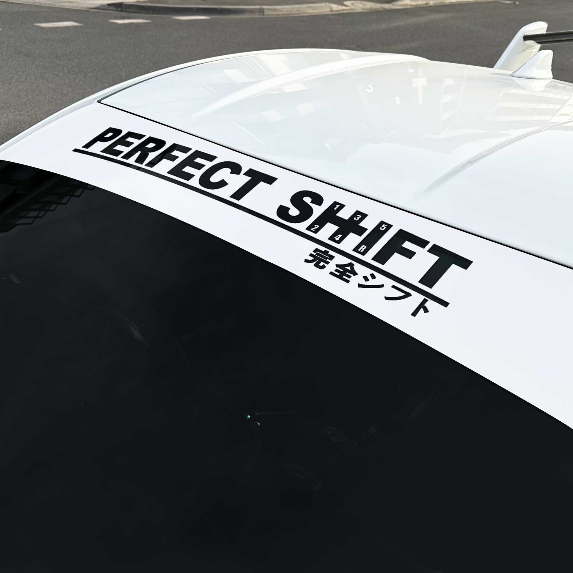 A branded Perfect Shift windshield banner with white background applied on a Toyota 86 that is parked on street