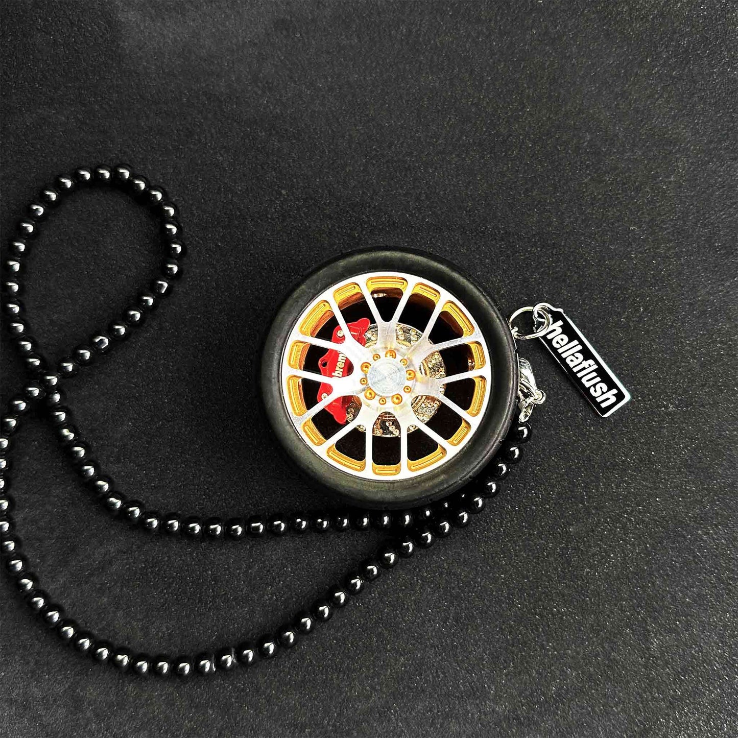 A yellow BBS wheel air-freshener placed on a black background